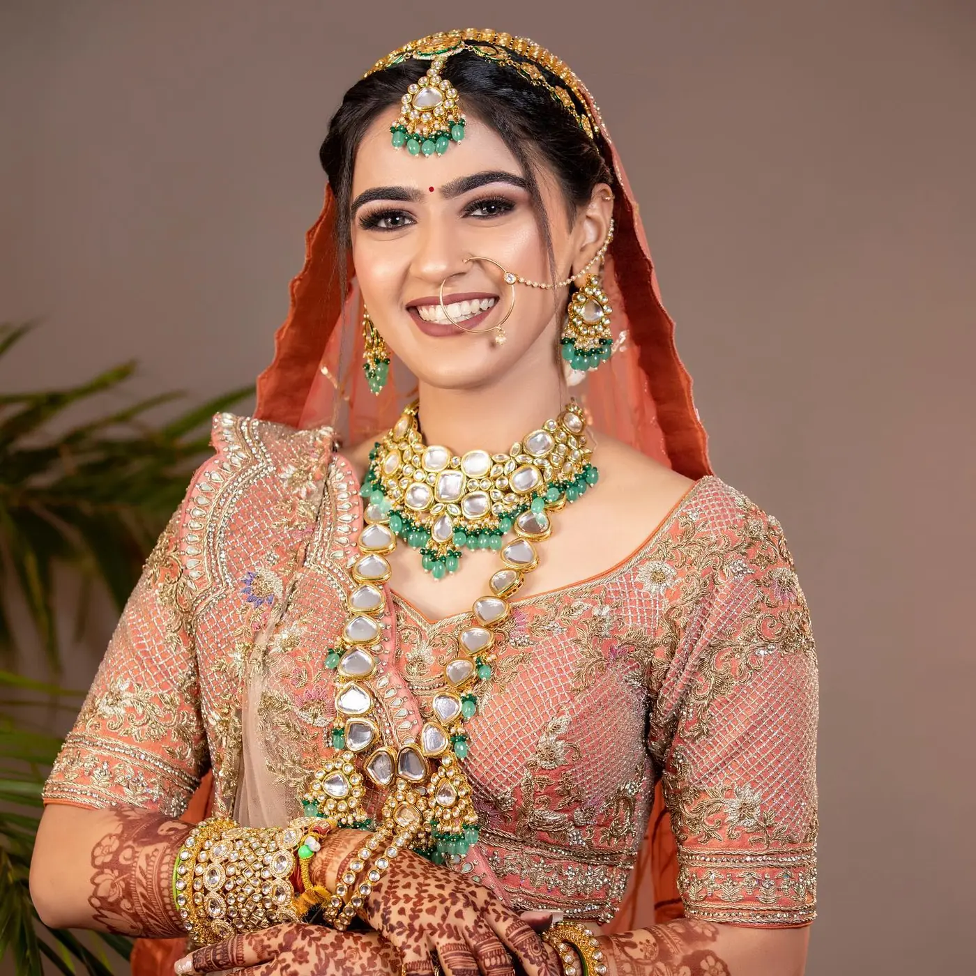 Peach Dupatta, Polki and Emerald Jewellery. Bridal makeup by Madhu Gupta at MG Makeovers, Gurugram